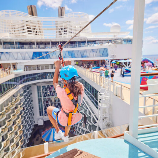 WN, Wonder of the Seas, woman riding on onboard Zipline, POV from behind, pool deck, fun,